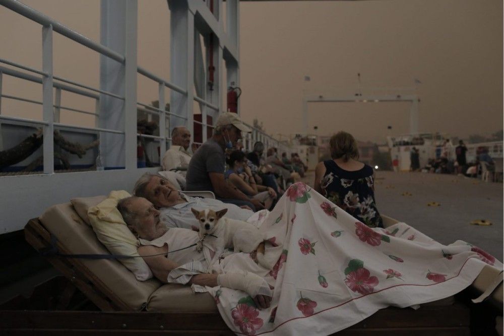 Φωτιά στην Εύβοια: Ηλικιωμένοι πάνω στο ferry boat με τον σκύλο τους αγκαλιά